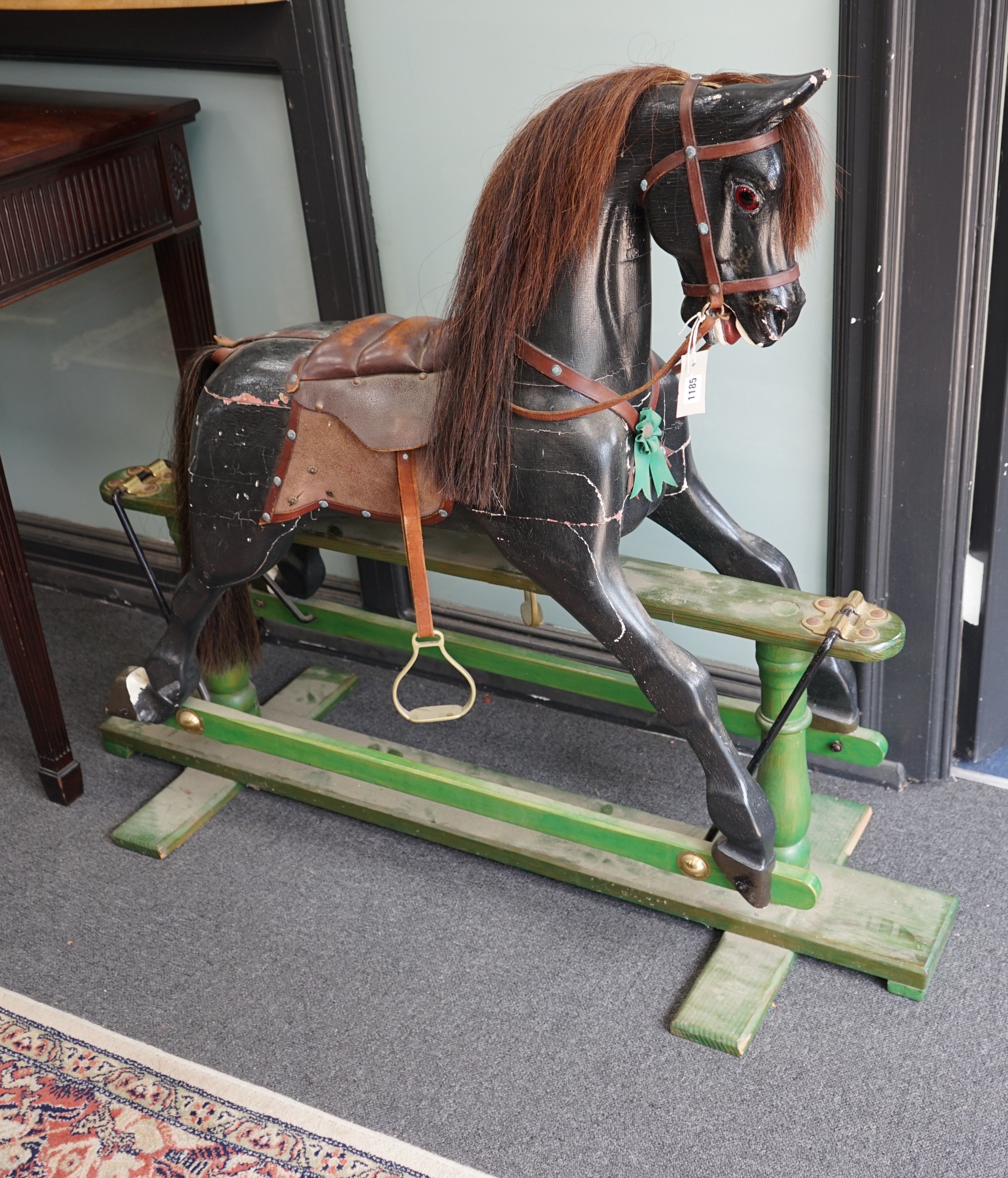 An early 20th century painted carved wood rocking horse on pine safety frame, length 132cm, height 107cm